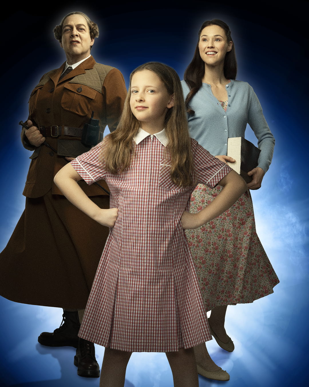 Flickan Matilda står i mitten. På ena sidan står en kvinna som ser sträng ut med ett spö i sin hand. På andra sidan står en yngre kvinna med mjukt ansiktsuttryck med en bok i handen.