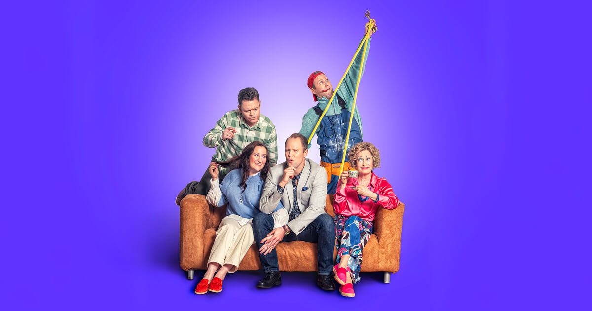 Skådespelarna för repertoaren En lysande idé sitter på en soffa tillsammans. Ett kärlekspar, en man med ett fundersamt ansiktsuttryck, en kvinna som dricker kaffe och en man med verktyg.